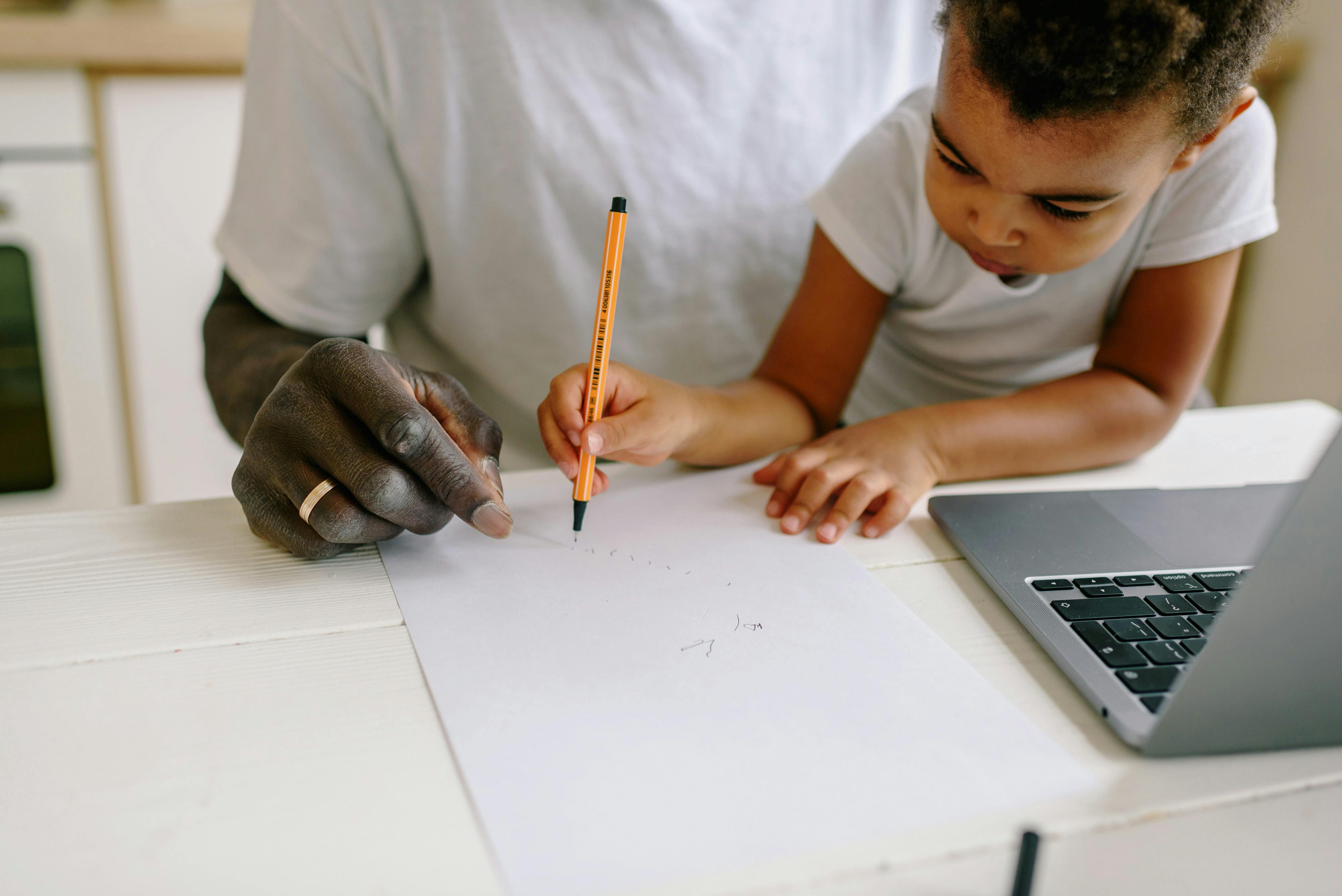 Father and son engage in a creative drawing session at home, fostering learning and connection.